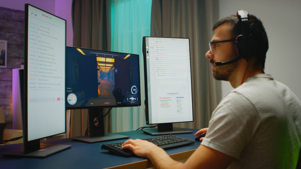 This image has an empty alt attribute; its file name is young-man-wearing-headphones-talking-with-other-players-while-playing-professional-shooter-games-online-tournament-1024x576.jpg